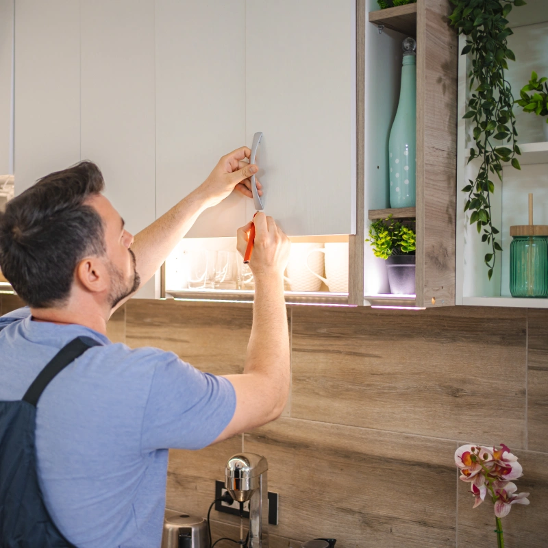 Handyman assembling furniture in contemporary kitchen